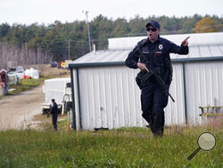 FILE - A police officer gives an order to the public during a manhunt for Robert Card at a farm following two mass shootings, Oct. 27, 2023, in Lisbon, Maine. Despite the warning by Card's friend and fellow Army reservist Sean Hodgson, which came alongside a series of other glaring red flags, Army officials discounted the warnings and ultimately did not stop Card from committing Maine's deadliest mass shooting when he killed multiple people in Lewiston. (AP Photo/Robert F. Bukaty, File)