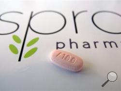In this June 22, 2015, photo, a tablet of flibanserin sits on a brochure for Sprout Pharmaceuticals in the company's Raleigh, N.C., headquarters. (AP Photo/Allen G. Breed)