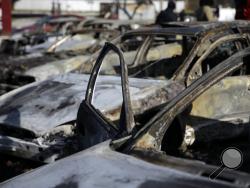 A row of burned cars sit on the lot of a used car dealer Tuesday, Nov. 25, 2014, in Dellwood, Mo. The cars are one example of property damage caused by rioters after a grand jury decided not to indict a Ferguson police officer in the shooting death of Michael Brown. (AP Photo/Jeff Roberson) 