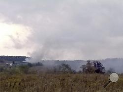 Smoke rises in the background as firefighters respond to a fire at the Flight 93 National Memorial headquarters Friday, Oct. 3, 2014, in Shanksville, Pa. National Park Service spokesman Mike Litterst says no injuries were reported Friday afternoon. He doesn't know the cause of the fire or the extent of the damage. (AP Photo/Daily American, Dylan Johnson)