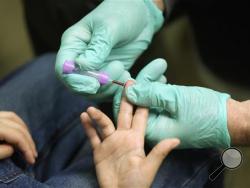 In this Jan. 26, 2016 file photo, registered nurse Brian Jones draws a blood sample from a student at Eisenhower Elementary School in Flint, Mich. The students were being tested for lead after the metal was found in the city's drinking water. Blood-lead levels in Flint children under the age of 6 were significantly higher after the city switched its water in 2014 in a cost-saving move, according to report released Friday, June 24, 2016, by U.S. disease experts. (AP Photo/Carlos Osorio, File)