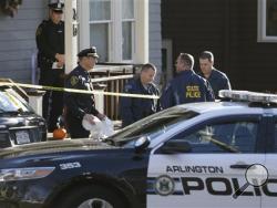 Law enforcement officials work behind a police vehicle outside a two-family home where four people were found dead Monday, Nov. 18, 2013 in Arlington, Mass. Arlington Police Chief Frederick Ryan said the bodies of two adults and two infants were found at the residence Monday. (AP Photo/Steven Senne)