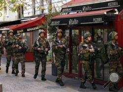 Soldiers operate in St. Denis, a northern suburb of Paris, Wednesday, Nov. 18, 2015. Authorities in the Paris suburb of St. Denis are telling residents to stay inside during a large police operation near France's national stadium that two officials say is linked to last week's deadly attacks. (AP Photo/Francois Mori)