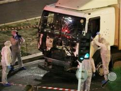 Authorities investigate a truck after it plowed through Bastille Day revelers in the French resort city of Nice, France, Thursday, July 14, 2016. France was ravaged by its third attack in two years when a large white truck mowed through revelers gathered for Bastille Day fireworks in Nice, killing at dozens of people as it bore down on the crowd for more than a mile along the Riviera city's famed seaside promenade. (Sasha Goldsmith via AP)