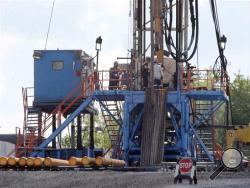 In this June 25, 2012 file photo, a crew works on a gas drilling rig at a well site for shale based natural gas in Zelienople, Pa. (AP Photo/Keith Srakocic, File)