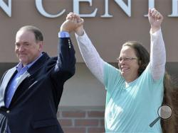 Rowan County Clerk Kim Davis, with Republican presidential candidate Mike Huckabee, left, at her side, greets the crowd after being released from the Carter County Detention Center, Tuesday, Sept. 8, 2015, in Grayson, Ky. (AP Photo/Timothy D. Easley)