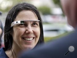 Cecilia Abadie wears her Google Glass as she talks with her attorney outside of traffic court Tuesday, Dec. 3, 2013, in San Diego. When Abadie was pulled over on suspicion of speeding in October, the officer saw she was wearing Google Glass and tacked on a citation usually given to drivers who may be distracted by a video or TV screen. She pleaded not guilty to both charges on Tuesday. (AP Photo/Lenny Ignelzi)