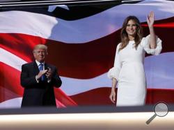 Melania Trump, wife of Republican Presidential Candidate Donald Trump, waves after addressing the delegate as her husband Donald Trump applauds during first day of the Republican National Convention in Cleveland, Monday, July 18, 2016. (AP Photo/Carolyn Kaster)