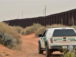 In this Jan. 4, 2016 photo, a U.S. Border Patrol agent drives near the U.S.-Mexico border fence in Santa Teresa, N.M. (AP Photo/Russell Contreras)