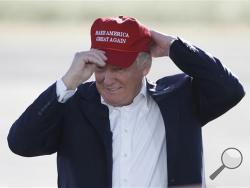 In this June 1, 2016, file photo, Republican presidential candidate Donald Trump wears his "Make America Great Again" hat at a rally in Sacramento, Calif. Trump’s “Make America Great Again” hats proudly tout they are “Made in USA.” Not necessarily always the case, an Associated Press review found. (AP Photo/Jae C. Hong, File)