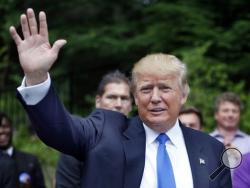 In this June 30, 2015, photo, Republican presidential candidate Donald Trump waves as he arrives at a house party in Bedford, N.H. (AP Photo/Jim Cole)