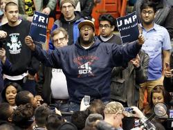 A protester holds up a ripped campaign sign for Republican presidential candidate Donald Trump before a rally on the campus of the University of Illinois-Chicago, Friday, March 11, 2016, in Chicago. (AP Photo/Charles Rex Arbogast)