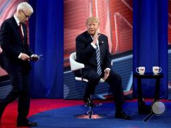 Republican presidential candidate Donald Trump, accompanied by Anderson Cooper, left, speaks with members of the audience during a commercial break at a CNN town hall at the University of South Carolina in Columbia, S.C., Thursday, Feb. 18, 2016. (AP Photo/Andrew Harnik)