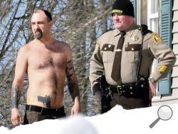 Michael Smith, left, bearing a realistic-looking tattoo of a handgun on his stomach, stands beside a Somerset County Sheriff deputy outside his home in Norridgewock, Maine. Smith was arrested Friday, June 13, 2014, after he allegedly showed up at a deputy’s home with a real gun in his waistband and drugs in his backpack. He was charged with stealing prescription narcotics from his girlfriend and released from the Somerset County Jail on $1,000 cash bail. It's not known if he has a lawyer. (AP Photo)
