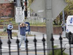 Edgar Maddison Welch, 28 of Salisbury, N.C., surrenders to police Sunday, Dec. 4, 2016, in Washington. Welch, who said he was investigating a conspiracy theory about Hillary Clinton running a child sex ring out of a pizza place, fired an assault rifle inside the restaurant on Sunday injuring no one, police and news reports said. (Sathi Soma via AP)