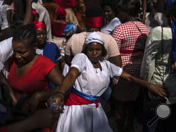 FILE - A Vodouist clad in white invokes a gede spirit during the Saint George celebration, in Port-au-Prince, Haiti, April 24, 2024. Shunned publicly by politicians and intellectuals for centuries, Vodou is transforming into a more powerful and accepted religion across Haiti, where its believers were once persecuted. (AP Photo/Ramon Espinosa, File)