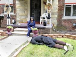 Jeannine Haddon poses on the porch of her Halloween decorated home, Friday, Oct. 9, 2015, in Detroit.(Charles V. Tines/Detroit News via AP) 