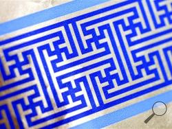 Cheryl Shapiro displays the Hanukkah gift wrap with a swastika-like pattern she found at Walgreens in Northridge, Calif., Monday, Dec. 8, 2014. The wrapping paper has been recalled from stores nationwide. (AP Photo/Los Angeles Daily News, Andy Holzman)