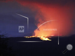 Lava pours out of the summit crater of Mauna Loa about 6:35 a.m. Monday, Nov. 28, 2022, as seen from Gilbert Kahele Recreation Area on Maunakea, Hawaii. Mauna Loa, the world’s largest active volcano, began spewing ash and debris from its summit, prompting civil defense officials to warn residents on Monday to prepare in case the eruption causes lava to flow toward communities. (Chelsea Jensen/West Hawaii Today via AP)