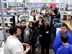 Best Buy employees stand in front of the line of patrons waiting to purchase a Xbox One console at the midnight doorbuster deal for Black Friday at the Best Buy located in Odessa, Texas. In the pre-dawn hours Friday, as some early-rising shoppers were heading into malls in search of Black Friday deals, others had been up shopping all night in stores that opened the evening of Thanksgiving or at 12:01 a.m. Friday. (AP Photo/Odessa American, Edyta Blaszczyk)