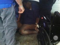 In this Monday, Dec. 21, 2015 photo provided by the family of Barbara Dawson, Dawson lies on the ground after collapsing on the floor in Blountstown, Fla. Dawson collapsed while being escorted in handcuffs from the hospital, where she sought treatment for breathing difficulties, Blountstown Police Chief Mark Mallory said. She was arrested for disorderly conduct and trespassing when she refused multiple requests to leave, Mallory said. (Courtesy of the family of Barbara Dawson via AP)