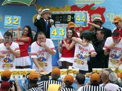 From left to right, Tim Janus, Joey Chestnut, Matt Stonie, and Erik Denmark compete during the Nathan's Famous Fourth of July International Hot Dog Eating contest at Coney Island, Friday, July 4, 2014, in New York. Chestnut won his eighth contest by finishing 61 hotdogs and buns. (AP Photo/John Minchillo)