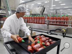 Sriracha chili sauce is produced at the Huy Fong Foods factory in Irwindale, Calif., on Tuesday, Oct 29, 2013. The maker of Sriracha hot sauce is under fire for allegedly fouling the air around its Southern California production site. The city of Irwindale filed a lawsuit in Los Angeles Superior Court Monday asking a judge to stop production at the Huy Fong Foods factory, claiming the chili odor emanating from the facility is a public nuisance. (AP Photo/Nick Ut)