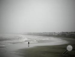 Robert Nicotra braves the wind and rain along the beach on the Isle of Palms, S.C., as Hurricane Matthew approaches, Friday, Oct. 7, 2016. (AP Photo/Mic Smith)