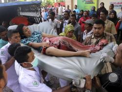 Hospital workers and family members carry a woman injured in an earthquake at a hospital in Pidie, Aceh province, Indonesia, Wednesday, Dec. 7, 2016. A strong undersea earthquake rocked Indonesia's Aceh province early on Wednesday, killing a number of people and causing dozens of buildings to collapse. (AP Photo/Heri Juanda)