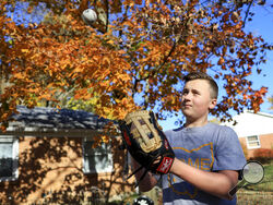 Liam Kennedy tosses a baseball he stands in his family's front yard Friday, Oct. 28, 2022, in Monroe, Ohio. (AP Photo/Aaron Doster)