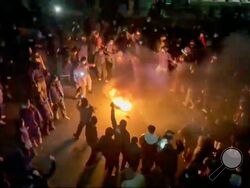 In this frame grab from footage circulating on social media shows protesters dancing and cheering around a bonfire as they take to the streets despite an intensifying crackdown as the Islamic Republic remains cut off from the rest of the world, in Tehran, Iran, Friday, Jan. 9, 2026.(UGC via AP)