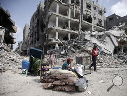 Palestinians sit by their belonginsg after visiting their houses destroyed in the Israeli offensive on Khan Younis, Gaza Strip, Wednesday, March 6, 2024. (AP Photo/Mohammed Dahman)