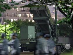 In this Monday, May 30, 2016 photo, Japan Self-Defense Force members walk near PAC-3 missile interceptors deployed to prepare for a possible North korean missile, at the Defense Ministry in Tokyo. (Muneki Yajima/Kyodo News via AP)