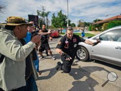 In this photo provided by OC Weekly a falling Ku Klux Klansman gets shoved by a counter-protester behind him, after members of the KKK tried to start an anti-immigration rally at Pearson Park in Anaheim on Saturday, Feb. 27, 2016. Three people were stabbed Saturday, one critically, after a small group of Ku Klux Klan members staging an anti-immigrant rally clashed with a larger gathering of counter-protesters, police said. (Eric Hood/OC Weekly via AP) 