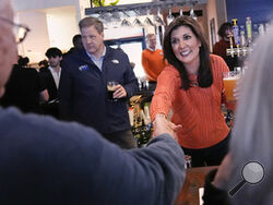 Republican presidential candidate former UN Ambassador Nikki Haley shakes hands with a patron during a campaign stop at a restaurant, Monday, Jan. 22, 2024, in Concord, N.H. At left is N.H. Gov. Chris Sununu. (AP Photo/Charles Krupa)