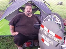 In this July 21, 2015 photo, Eric Hites, rests at the Bliss Congregational Church in Tiverton, R.I., while he waits for a new bicycle so he can continue his cross-country ride. The about 560-pound man is biking across the United States to lose weight. (Marcia Pobzeznik/The Daily News via AP)
