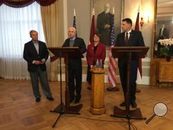 Latvian President Raimonds Vejonis, right, looks at US Sen. John McCain centre left, during a press conference, Wednesday, Dec. 28, 2016 in Riga, Latvia, while Lindsey Graham, R-SC., and Amy Klobuchar, D-Minn., stand in the background. Russia can expect hard-hitting sanctions from United States lawmakers if an investigation proves that Moscow interfered in the presidential election, a U.S. senator said Wednesday during a visit to Latvia. (AP Photo/Vitnija Saldava)