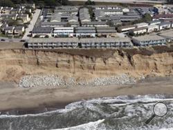 In this image provided by the California Coastal Records Project, cliff erosion is seen below the Esplanade Apartments in Pacifica, Calif., in 2009. AP Photo/Kenneth Adelman/California Coastal Records Project via AP)