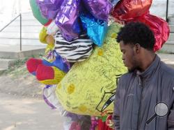In this Aug. 27, 2015 photo, Jamel Russel, 17, looks at a memorial for his friend Breanna Eskridge, who was gunned down on her grandmother's front porch in Milwaukee. Community activists and city officials across the U.S. grapple with whether, or when, to remove tributes to victims of gun violence. In Milwaukee, victims' advocates are leading a push to establish publicly funded individual tributes to replace makeshift shrines. (AP Photo/Greg Moore)