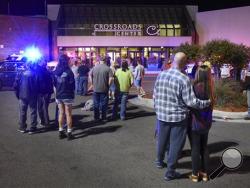 People stand near the entrance on the north side of Crossroads Center shopping mall in St. Cloud, Minn., Saturday, Sept. 17, 2016. Several people were taken to a hospital with injuries after a stabbing attack at the mall, which ended with the suspected attacker dead inside the mall. (Dave Schwarz/St. Cloud Times via AP)