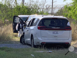 A Mexican police investigator inspects the minivan were four Americans where shot and taken from last week, at the Tamaulipas State Prosecutor´s headquarters in Matamoros, Mexico, Wednesday, March 8, 2023. Their minivan crashed and was fired on shortly after they crossed into the border city of Matamoros on Friday as drug cartel factions tore through the streets, the region's governor said. A stray bullet also killed a Mexican woman about a block and a half away. (AP Photo)