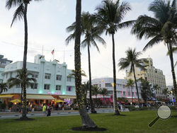 Pedestrians walk along Ocean Drive with its beautiful Art Deco buildings, Tuesday, Feb. 27, 2024, in Miami Beach, Fla. Miami Beach officials are implementing a series of measures to discourage non residents from going to South Beach for spring break. They include curfews, DUI checkpoints and closing parking garages. (AP Photo/Marta Lavandier)
