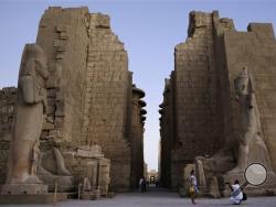  In this Sunday, Nov. 30, 2014, file photo a tourist has her picture taken at the ruins of the Karnak Temple in Luxor, Egypt. (AP Photo/Hassan Ammar, File)
