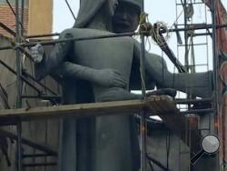 A sculpture, titled “Mother of the Martyr,” depicts a slender peasant woman, a traditional artistic representation of Egypt, with her arms outstretched with a helmeted soldier standing behind her, at a public square in Sohag, Egypt. A provincial governor in Egypt has ordered changes to a sculpture honoring fallen soldiers after many on social media said it appeared to depict an unwanted advance on a woman symbolizing the country. (AP Photo/Mahmoud Ahmed)