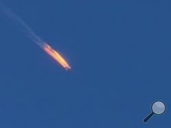 This frame grab from video by Haberturk TV, shows a Russian warplane on fire before crashing on a hill as seen from Hatay province, Turkey, Tuesday, Nov. 24, 2015. Turkey shot down the Russian warplane Tuesday, claiming it had violated Turkish airspace and ignored repeated warnings. Russia denied that the plane crossed the Syrian border into Turkish skies. (Haberturk TV via AP) 