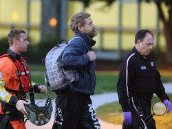 Louis Jordan, center, walks from the Coast Guard helicopter to the Sentara Norfolk General Hospital in Norfolk, Va., after being found off the North Carolina coast, Thursday, April 2, 2015. His family says he sailed out of a marina in Conway, South Carolina, on Jan. 23, and hadn't been heard from since. (AP Photo/The Virginian-Pilot, Steve Earley)