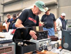 In this Sept. 18, 2016, photo, vendor Chuck Ochs shows a 1921 Crosley Model 51 radio, priced at $100, at MIT's Radio Society flea market on the campus of the Massachusetts Institute of Technology in Cambridge, Mass. Every third Sunday, MIT's Radio Society hosts a parking-lot flea market that's part yard sale and part curio museum from the world of electronics. Vendors come to hawk radio equipment, but also vintage Macintosh computers, castaway musical instruments, baubles of all kinds and the occasional spa