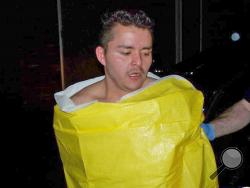 In this photo released by the Keizer, Ore., Police Department, 24-year-old Guillermo Brambila Lopez, of Woodburn, Ore., is wrapped in a blanket following his arrest, Sunday, Jan. 4, 2015. Police said Lopez broke into two homes in Keizer, drinking alcohol and using the hot tub at one of them. (AP Photo/Keizer Police Department) 