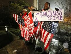 Protesters react outside the Dekalb County, Ga., courthouse after it was announced that a grand jury decided to indict a Dekalb County police offer accused of shooting an unarmed naked man in March, on Thursday, Jan. 21, 2016, in Decatur, Ga. (AP Photo/John Bazemore)