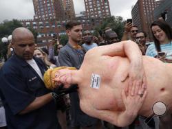 An employee of the New York City Department of Parks & Recreation removes a statue of a naked Republican presidential candidate Donald Trump, Thursday, Aug. 18, 2016 in New York's Union Square. (AP Photo/Mary Altaffer)